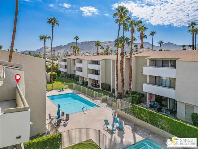 view of swimming pool with a mountain view and a patio