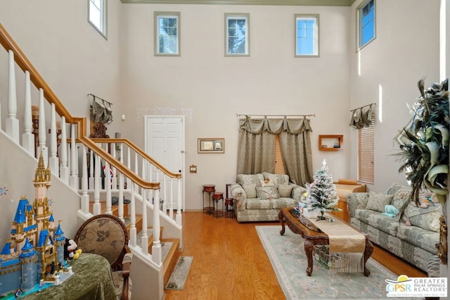 living room with a high ceiling and light hardwood / wood-style flooring