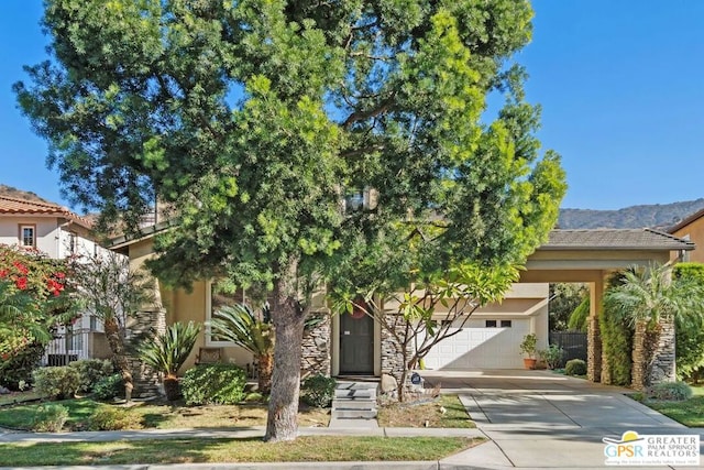 view of property hidden behind natural elements with a mountain view and a garage