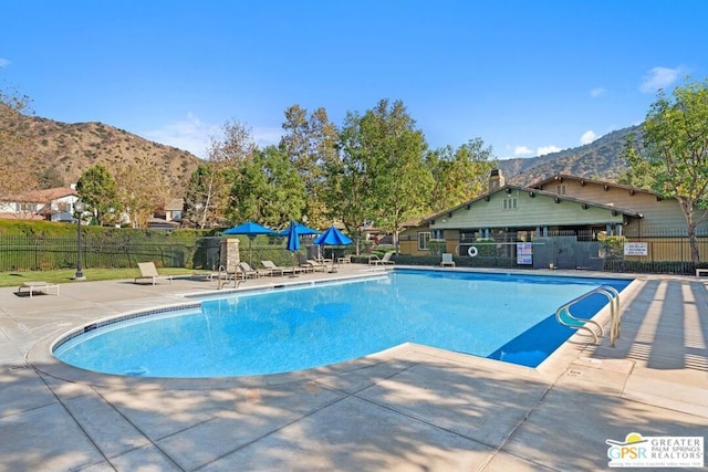 view of pool featuring a mountain view and a patio