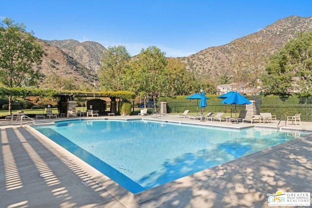 view of swimming pool with a mountain view and a patio