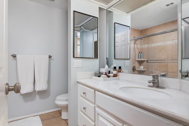 bathroom featuring toilet, tile patterned flooring, a shower with door, and vanity