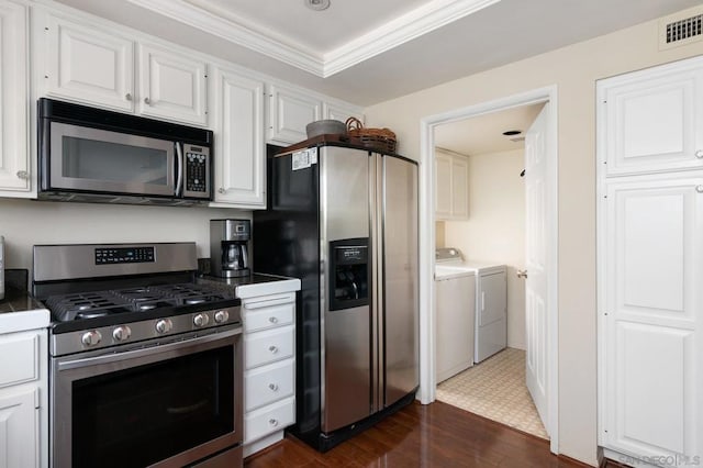 kitchen featuring washing machine and dryer, crown molding, stainless steel appliances, white cabinets, and dark hardwood / wood-style flooring