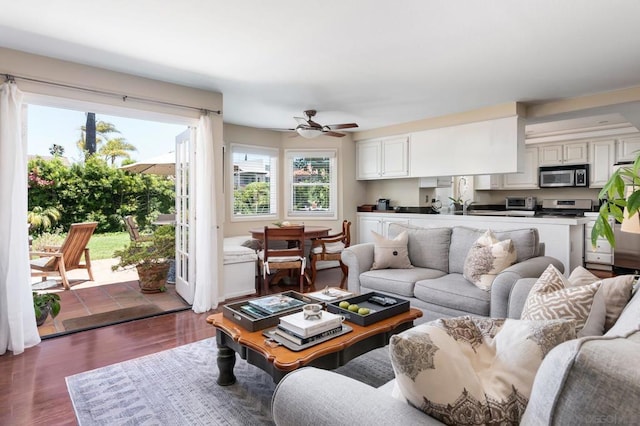 living room featuring ceiling fan and dark hardwood / wood-style floors