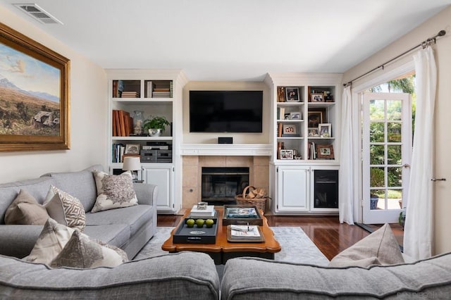 living room with dark wood-type flooring and a fireplace