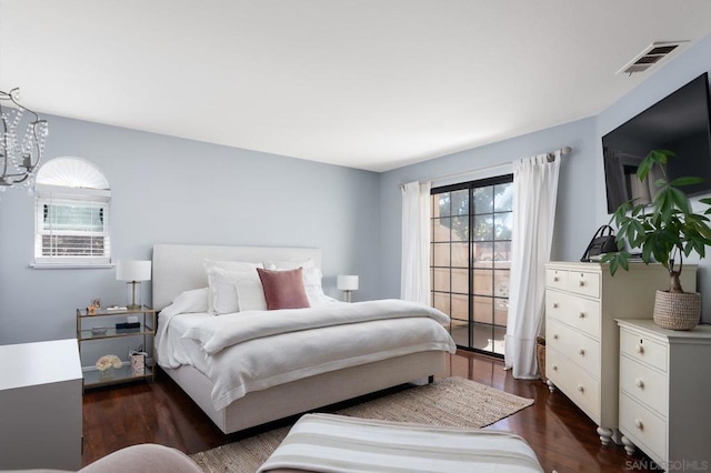 bedroom featuring dark hardwood / wood-style floors and a chandelier