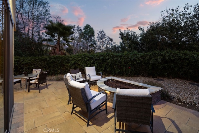 patio terrace at dusk with a fire pit and outdoor dining area