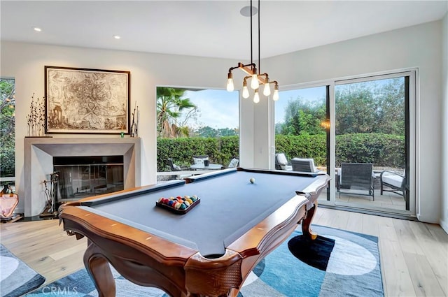 recreation room with billiards, a glass covered fireplace, wood finished floors, an inviting chandelier, and recessed lighting