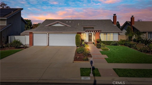 view of front of property featuring a garage and a lawn