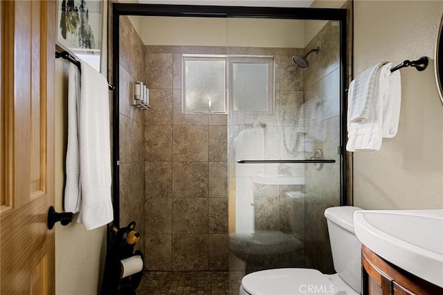 bathroom with toilet, vanity, and an enclosed shower