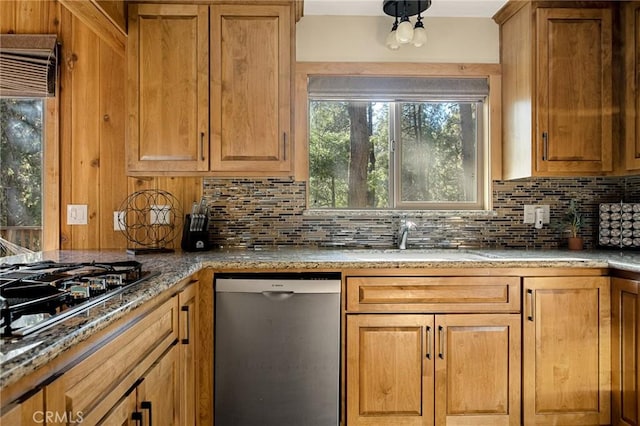 kitchen featuring gas stovetop, stainless steel dishwasher, tasteful backsplash, and sink