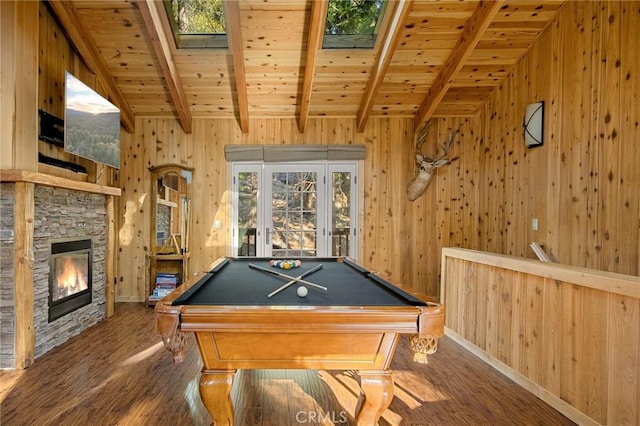 rec room featuring dark hardwood / wood-style floors, wood walls, wood ceiling, a stone fireplace, and pool table