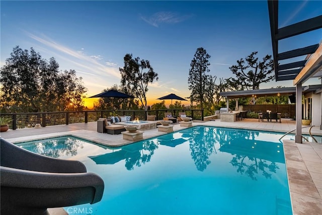 pool at dusk featuring a patio area and a fire pit