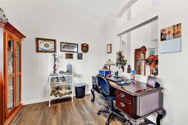 office area with a high ceiling and hardwood / wood-style floors