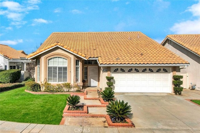 mediterranean / spanish-style home featuring a garage and a front lawn