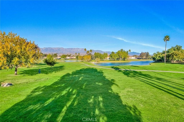 view of property's community featuring a lawn and a water and mountain view