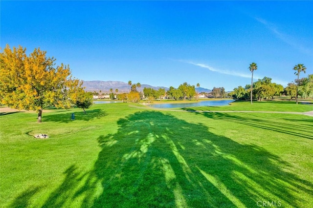 view of property's community with a lawn and a water and mountain view