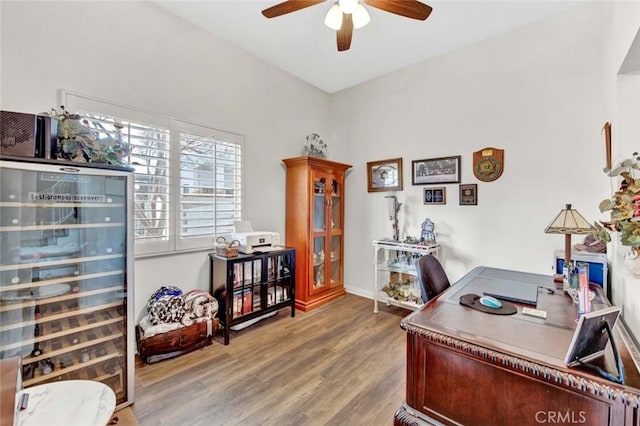 office area featuring ceiling fan, beverage cooler, and hardwood / wood-style floors