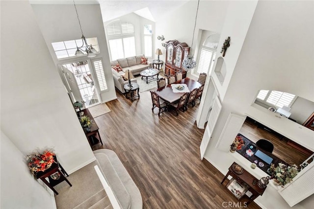 entrance foyer with a towering ceiling, an inviting chandelier, and hardwood / wood-style flooring