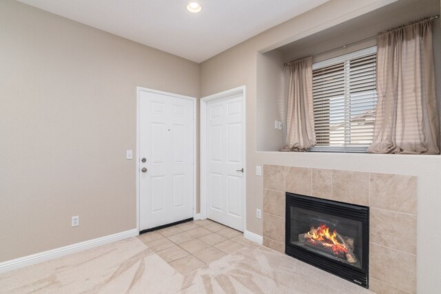 interior space with light tile patterned floors and a tiled fireplace