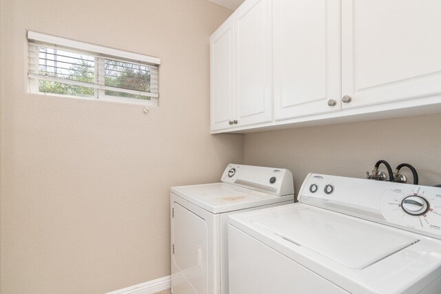 washroom with cabinets and separate washer and dryer