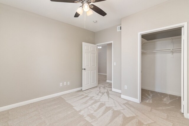 unfurnished bedroom featuring ceiling fan, light colored carpet, and a closet