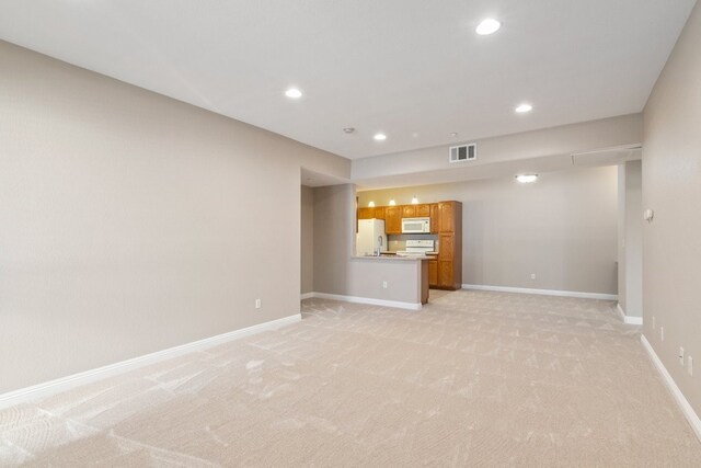 unfurnished living room featuring light colored carpet