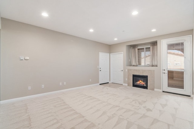 unfurnished living room with light colored carpet and a tile fireplace