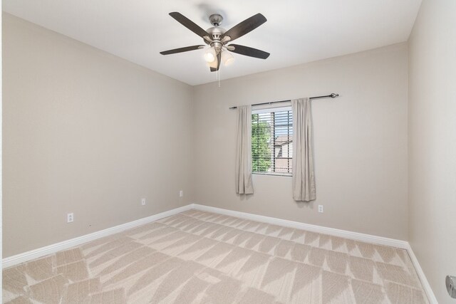 spare room with ceiling fan and light colored carpet