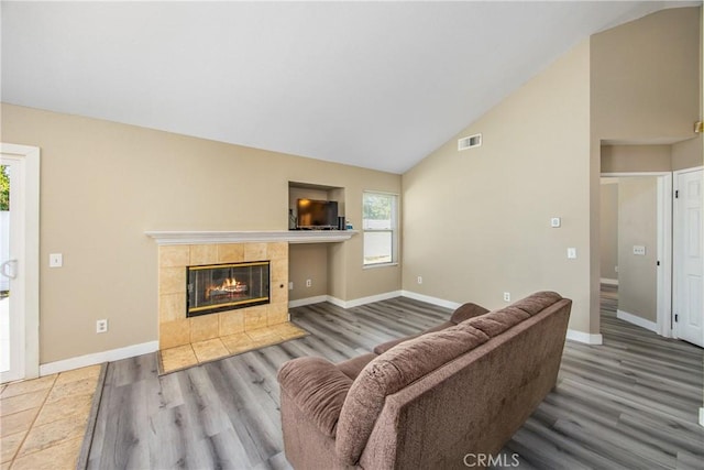 living room with a fireplace, plenty of natural light, and wood-type flooring