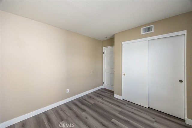 unfurnished bedroom featuring dark hardwood / wood-style floors and a closet