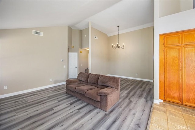 living room with light hardwood / wood-style flooring, high vaulted ceiling, and a chandelier