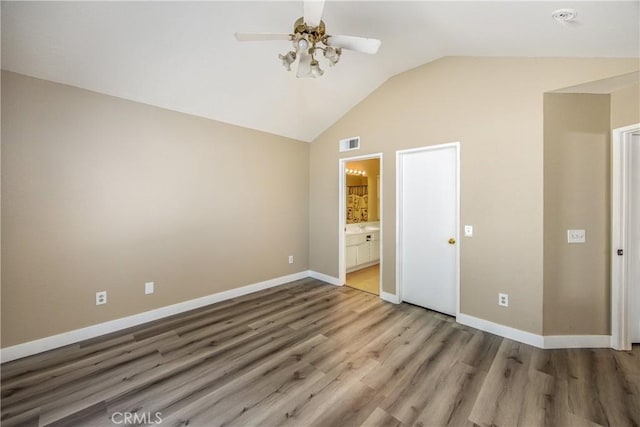 unfurnished bedroom with hardwood / wood-style flooring, ceiling fan, lofted ceiling, and ensuite bathroom