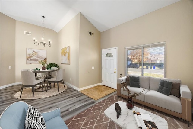 living room featuring an inviting chandelier, dark wood-type flooring, and high vaulted ceiling