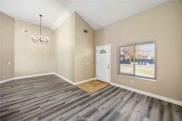 foyer featuring hardwood / wood-style flooring, a chandelier, and high vaulted ceiling