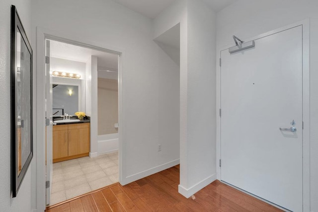 hallway featuring light wood-type flooring and sink