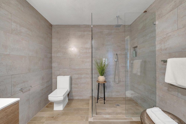 bathroom featuring tile walls, tiled shower, and toilet