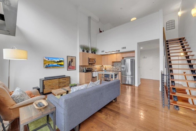 living room featuring light hardwood / wood-style floors and a high ceiling