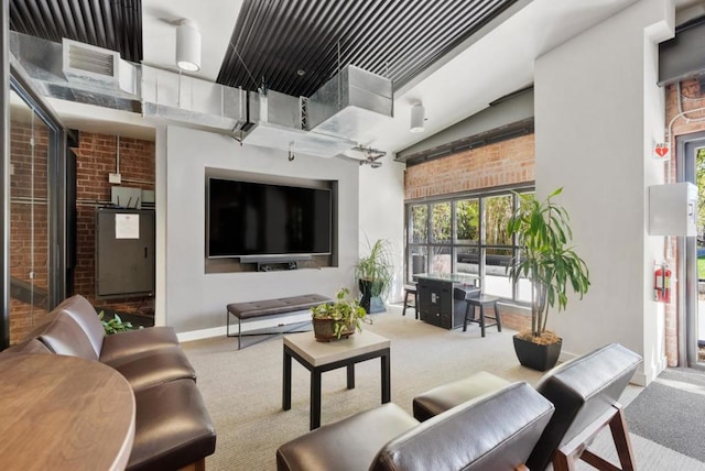 carpeted living room with brick wall