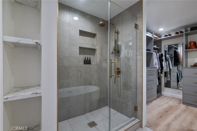 bathroom with a shower with shower door and hardwood / wood-style flooring