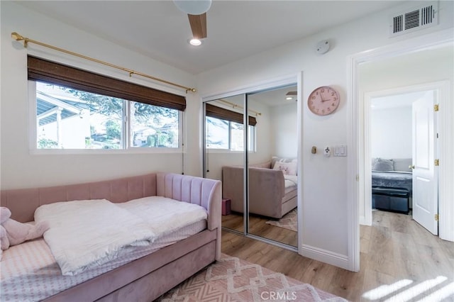 bedroom featuring ceiling fan, a closet, and light hardwood / wood-style floors