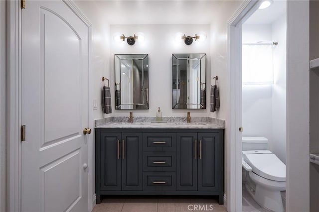 bathroom featuring toilet, tile patterned floors, and vanity