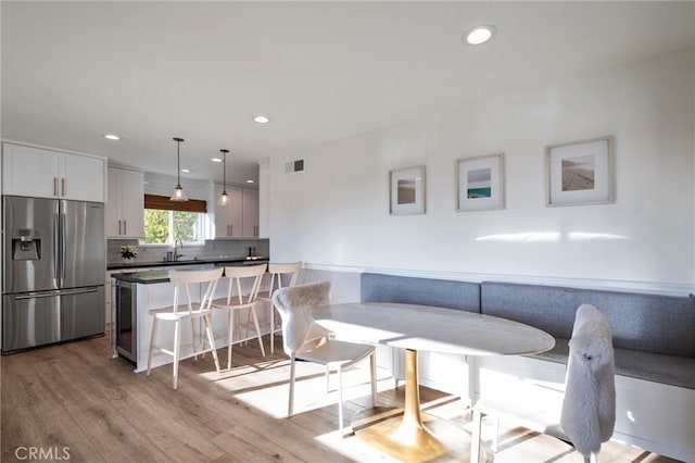 dining space with light hardwood / wood-style flooring and sink