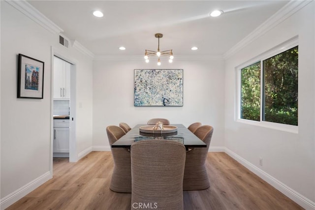 dining area featuring ornamental molding and light hardwood / wood-style flooring