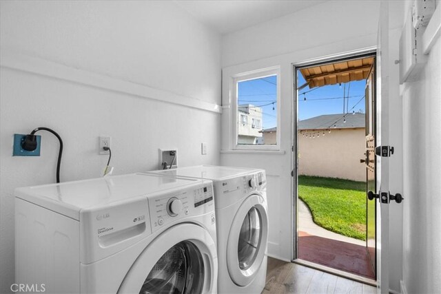 clothes washing area with wood-type flooring and washing machine and clothes dryer