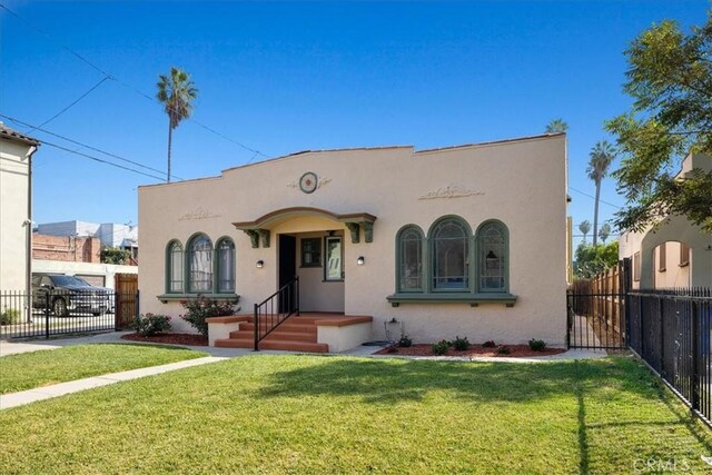 mediterranean / spanish home featuring a front lawn