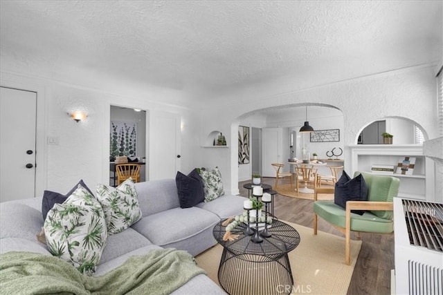 living room with a textured ceiling and hardwood / wood-style flooring