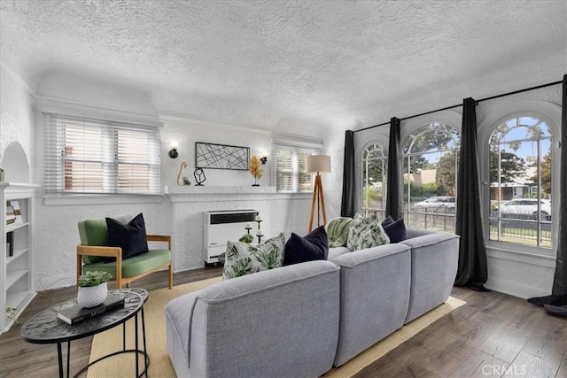 living room featuring heating unit, a healthy amount of sunlight, dark hardwood / wood-style flooring, and a textured ceiling