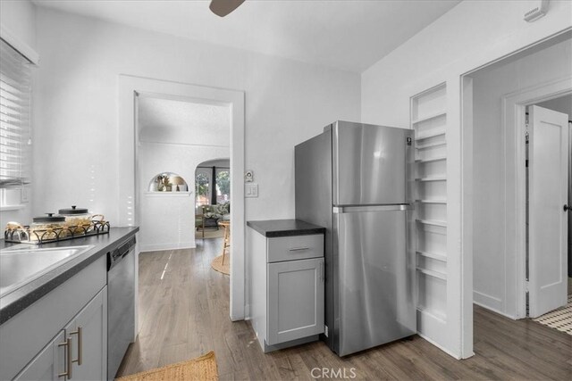 kitchen featuring ceiling fan, dark hardwood / wood-style floors, gray cabinets, sink, and appliances with stainless steel finishes