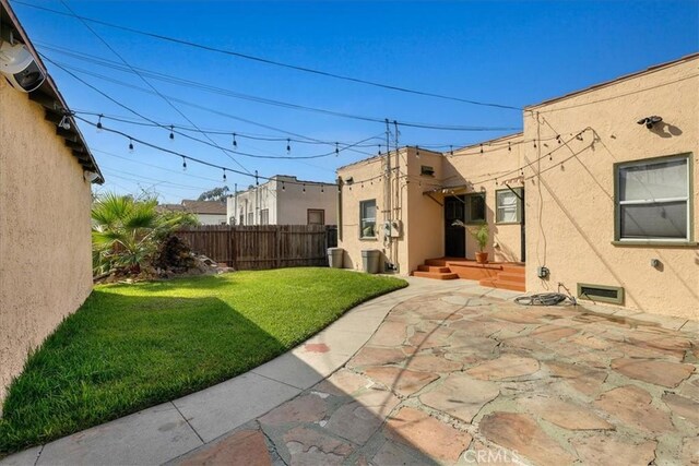 rear view of property featuring a patio area and a yard